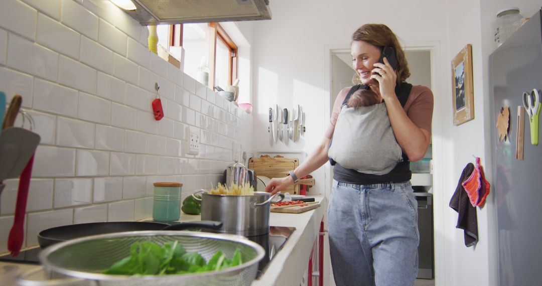 Caucasian Mother Multitasking with Baby Carrier in Kitchen