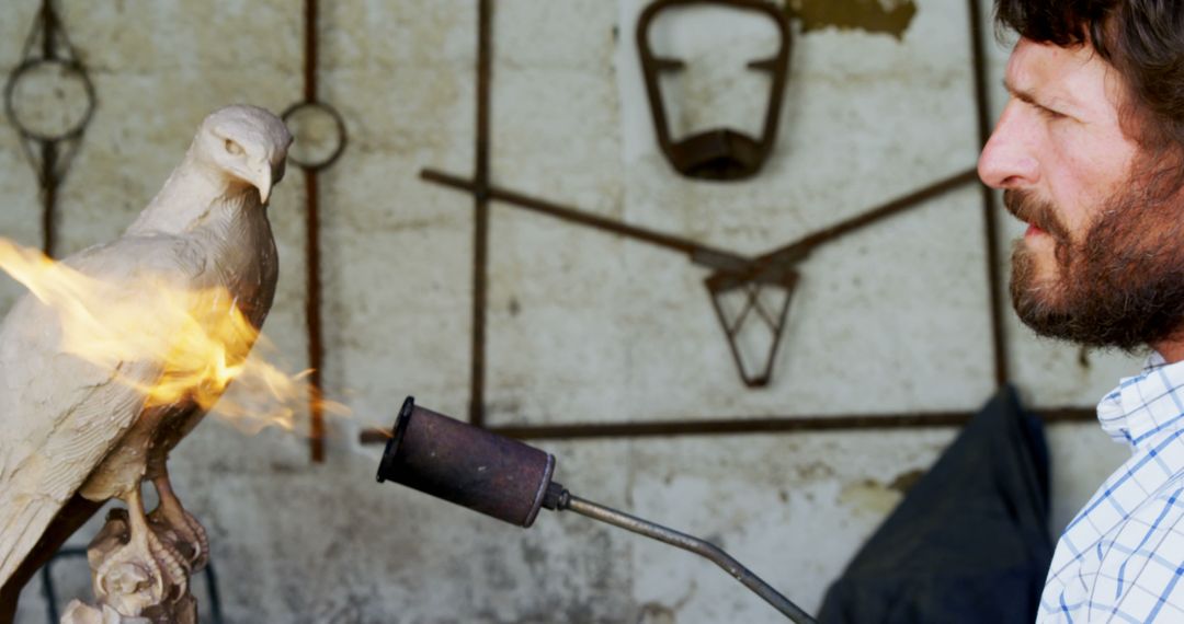 Man sculpting bird with blowtorch in workshop - Free Images, Stock Photos and Pictures on Pikwizard.com