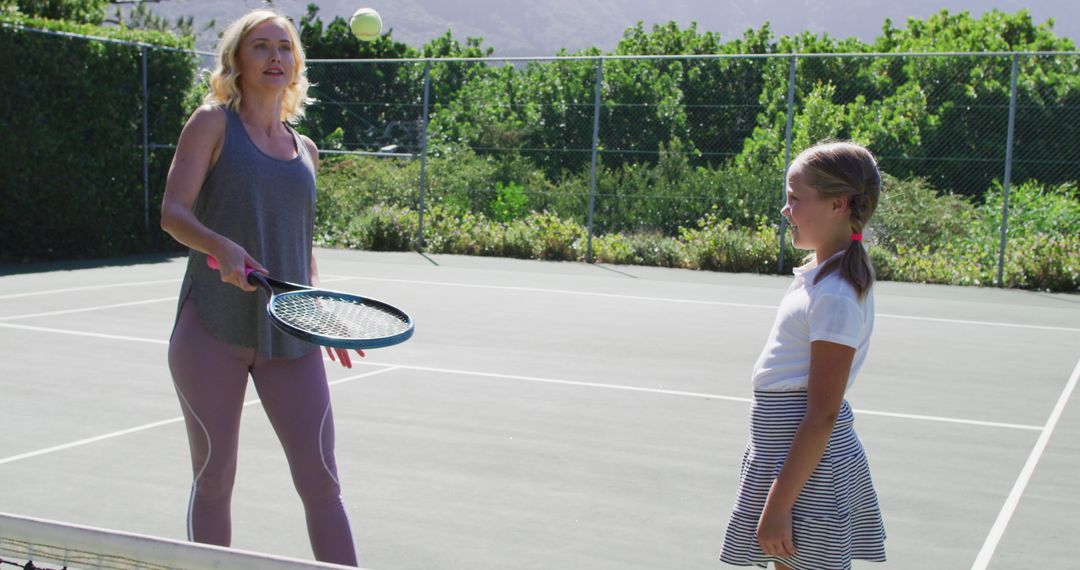 Mother and Daughter Playing Tennis on Outdoor Court - Free Images, Stock Photos and Pictures on Pikwizard.com