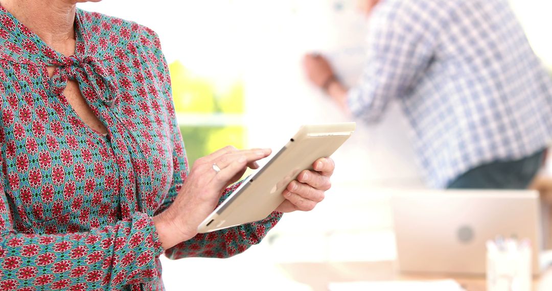 Middle-Aged Woman Using Tablet in Office Environment