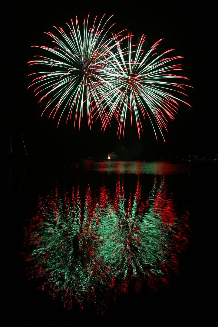 Stunning Red and Green Fireworks Reflecting on Water at Night - Free Images, Stock Photos and Pictures on Pikwizard.com