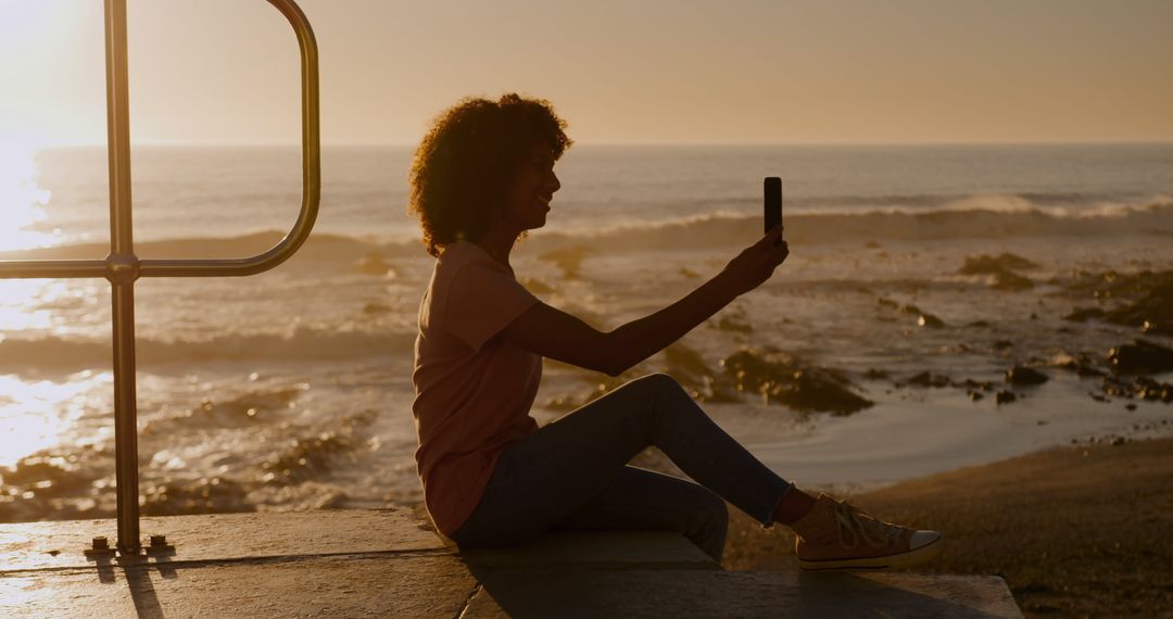 Young Woman Taking Selfie by Ocean at Sunset - Free Images, Stock Photos and Pictures on Pikwizard.com