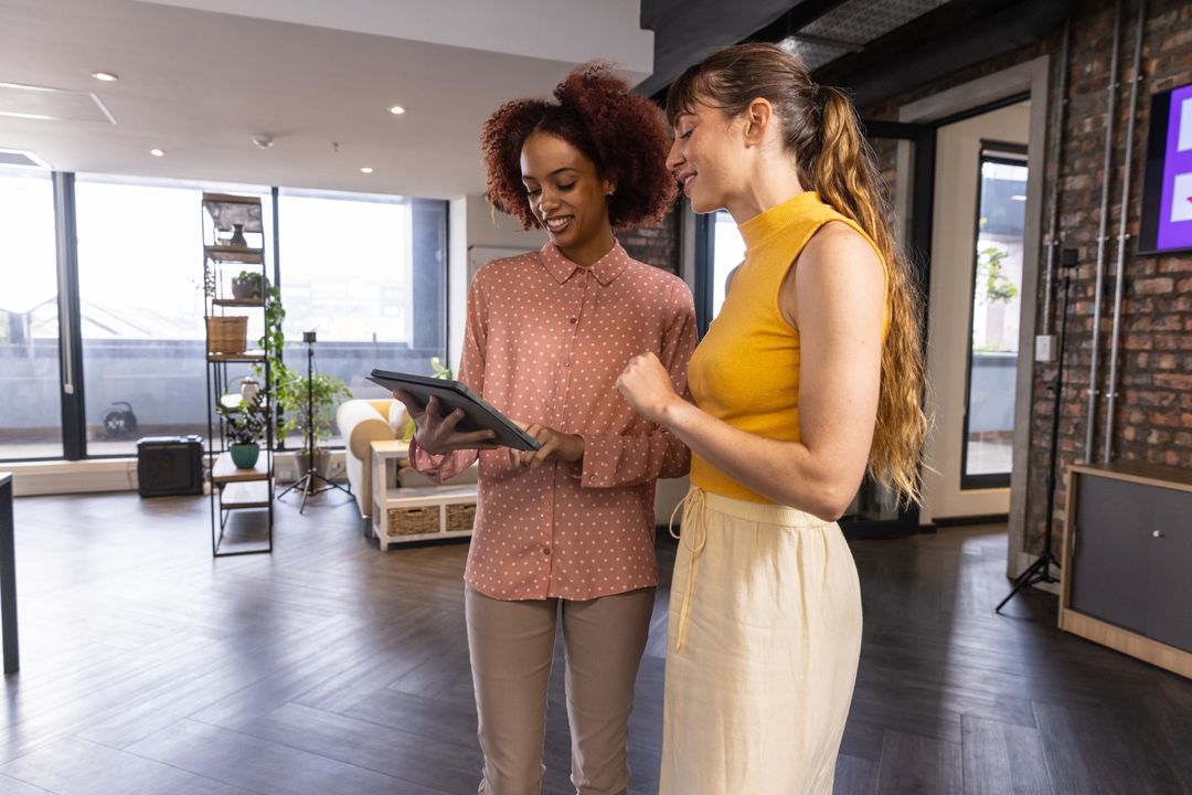 Diverse Coworkers Collaborating in Modern Workspace with Tablet