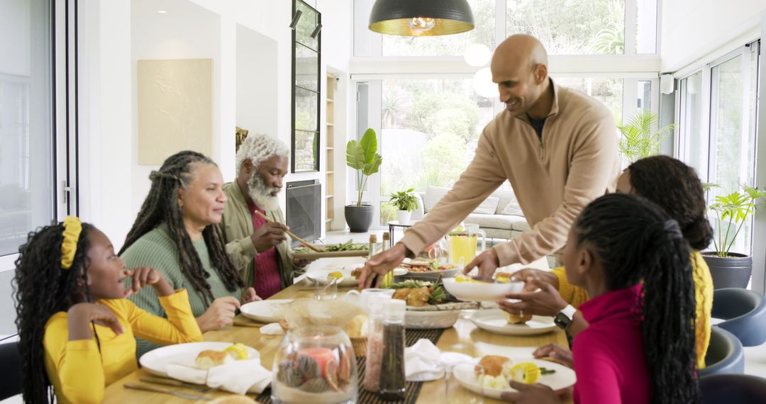 Multi-generational family sharing sunlit meal in modern dining space, passing dishes and warmth