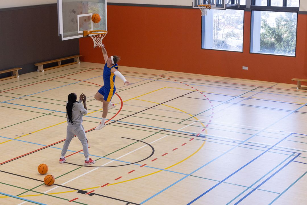 Basketball Player Dunking After Training Tips from Coach in Gym