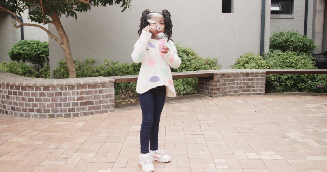 Joyful Child Blowing Bubbles in Courtyard