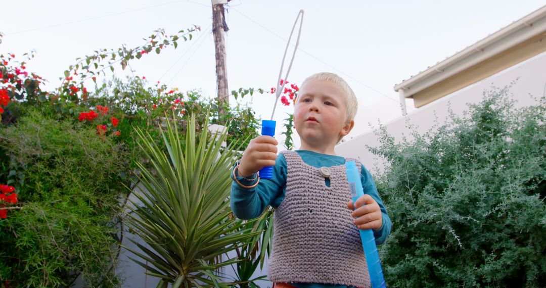 Young Boy Joyfully Playing with Bubble Wand in Lush Garden