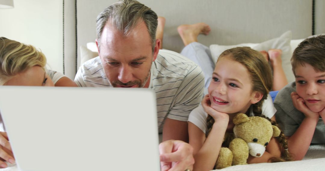 Father With Children Using Laptop on Bed, Spending Family Time - Free Images, Stock Photos and Pictures on Pikwizard.com