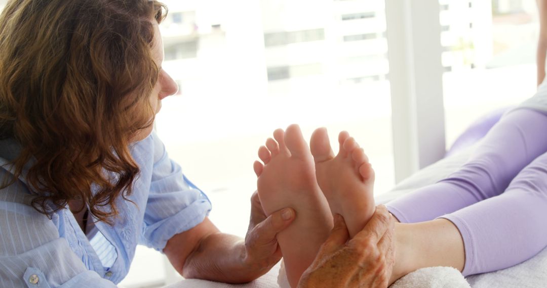 Therapist Providing Relaxing Foot Massage to Woman in Spa Clinic - Free Images, Stock Photos and Pictures on Pikwizard.com