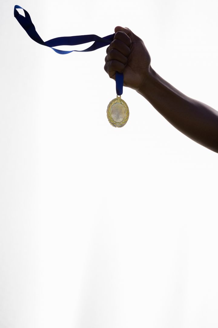 Athlete Holding Gold Medal Against White Background - Free Images, Stock Photos and Pictures on Pikwizard.com