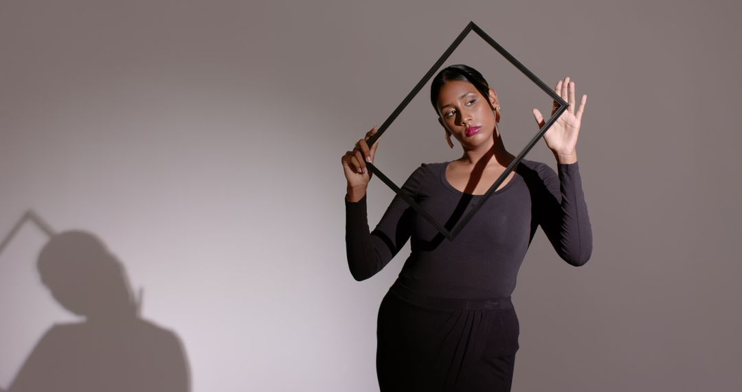 Elegant Minimalist Portrait of Woman with Black Frame Against Soft Lighting