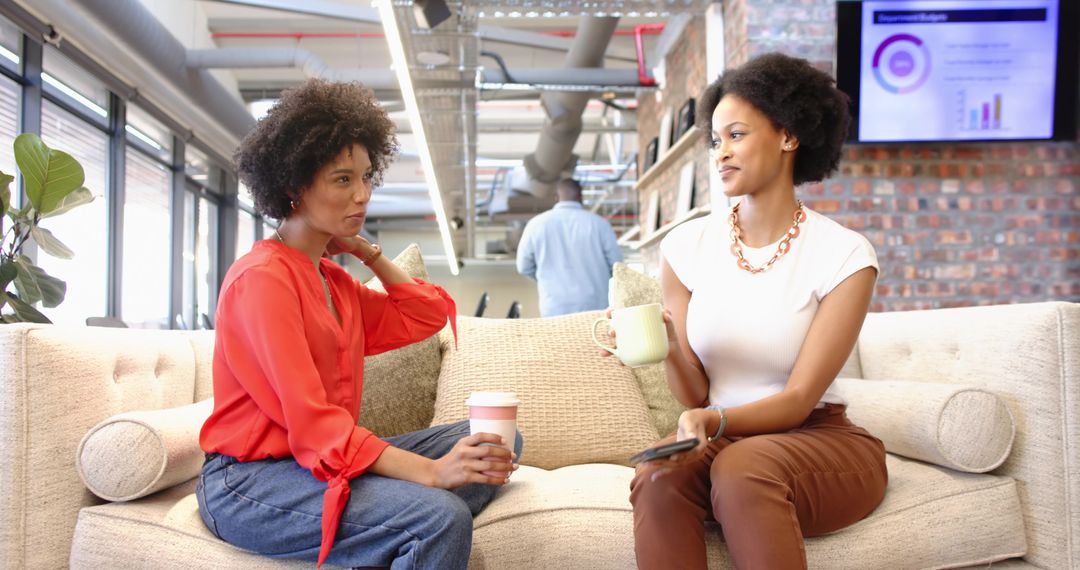 Coworkers Engaging in Informal Chat with Coffee in Trendy Office