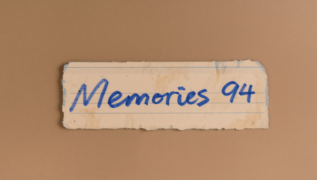 Vintage torn notebook strip featuring Memories 94 handwritten label on brown backdrop