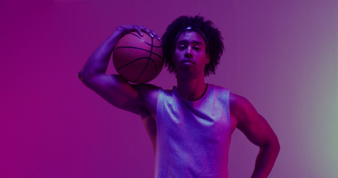 Image of biracial male basketball player with ball on purple to green background - Free Images, Stock Photos and Pictures on Pikwizard.com
