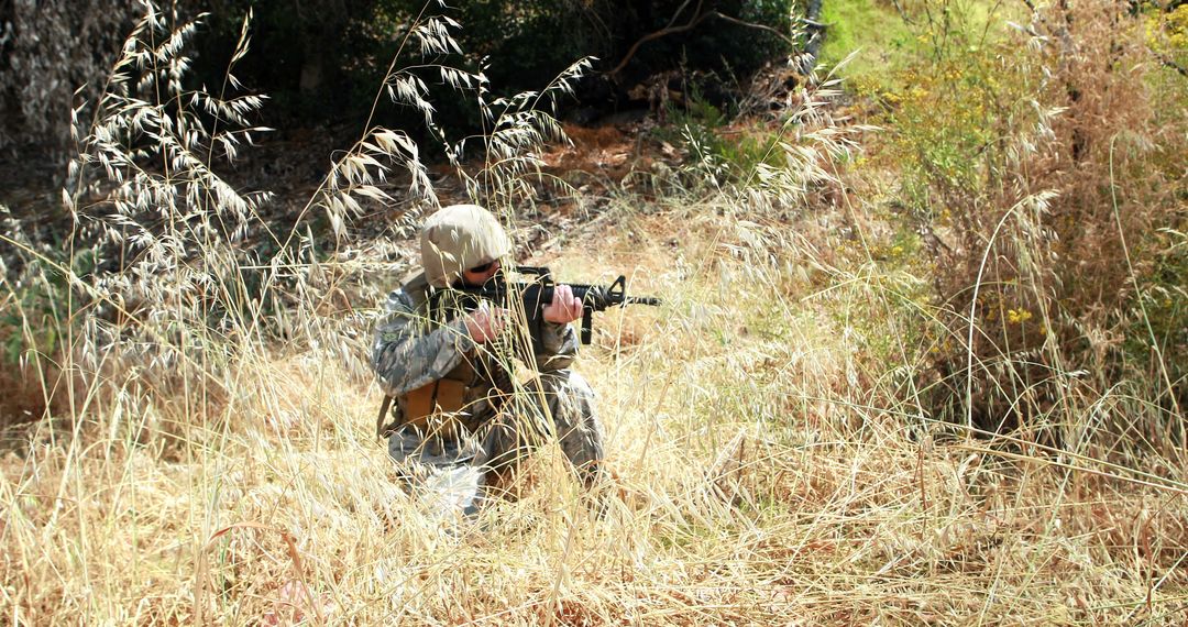 Soldier in camo gear holding rifle in tall grass during daytime - Free Images, Stock Photos and Pictures on Pikwizard.com