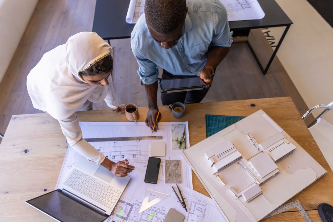 Diverse Coworkers Collaborating on Architectural Project in Office