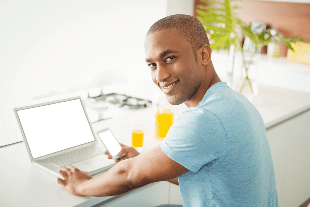 Smiling Man at Home Using Smartphone and Laptop with Transparent Screens
