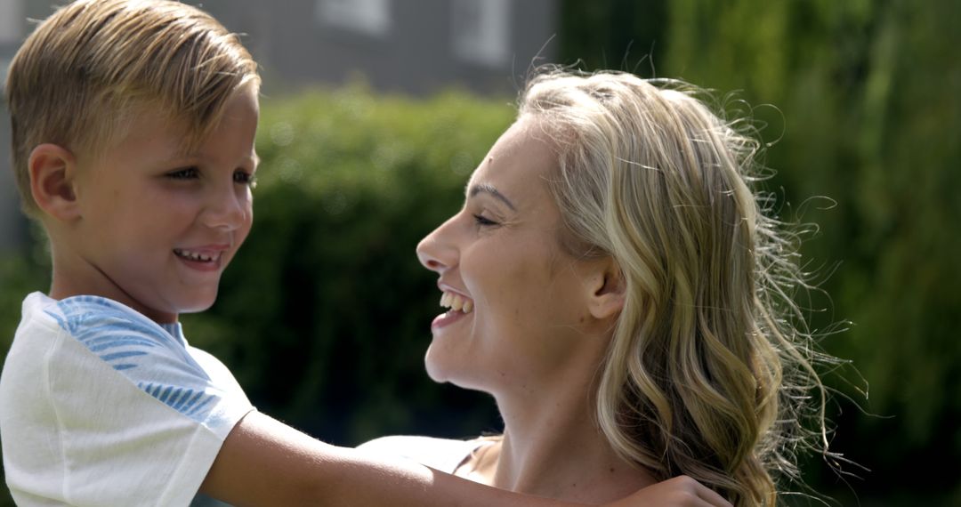 Mother Holding Son Smiling Outdoors in Summer Sunshine - Free Images, Stock Photos and Pictures on Pikwizard.com