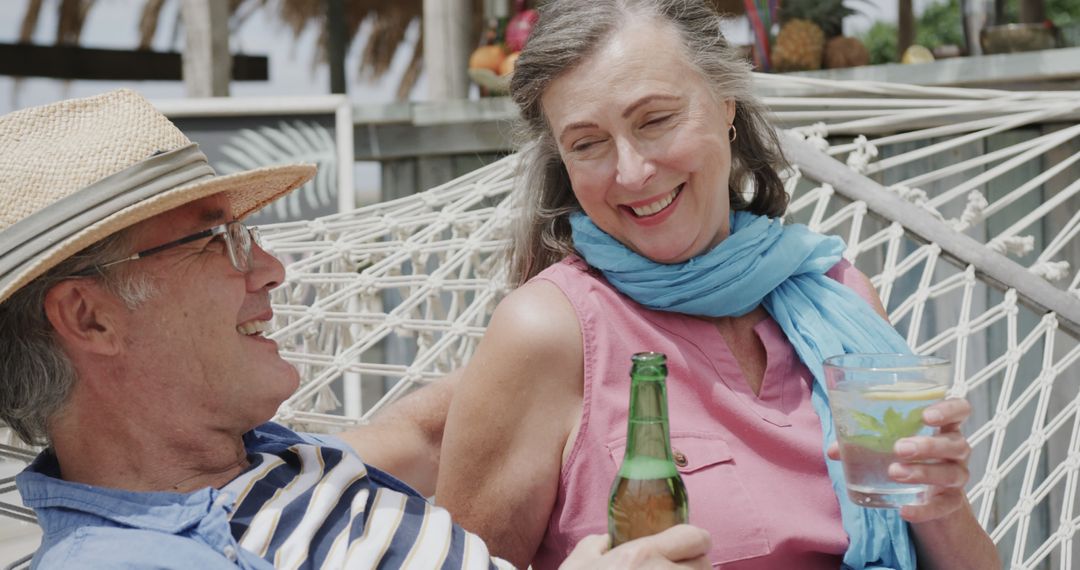 Happy Elderly Couple Relaxing on Hammock Drinking Beverages - Free Images, Stock Photos and Pictures on Pikwizard.com