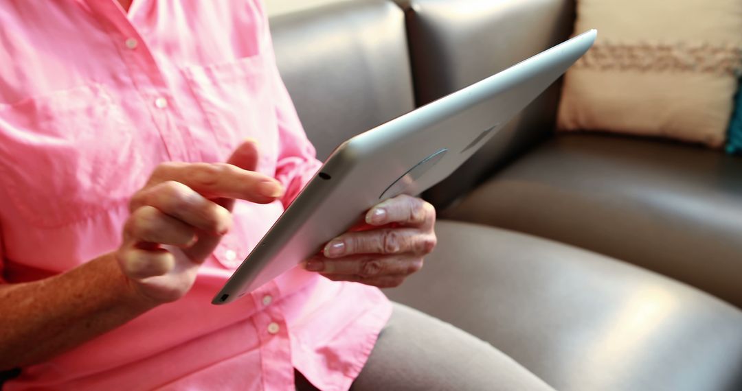 Senior Woman Using Tablet, Sitting on Couch at Home - Free Images, Stock Photos and Pictures on Pikwizard.com