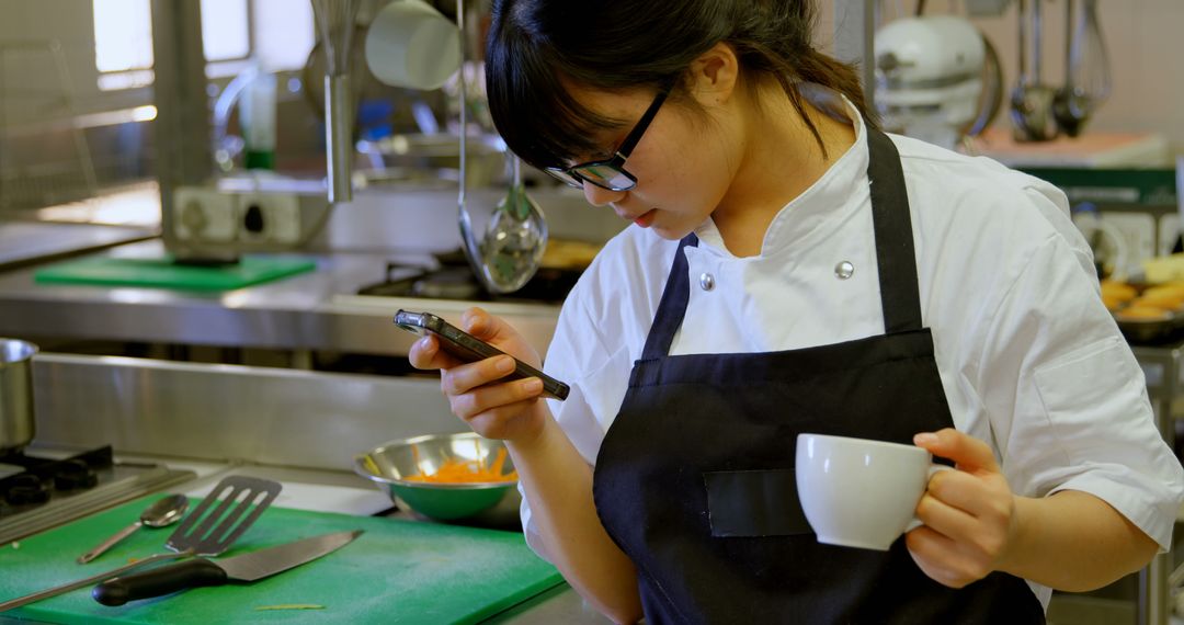 Young Asian female chef multi-tasking in professional kitchen - Free Images, Stock Photos and Pictures on Pikwizard.com