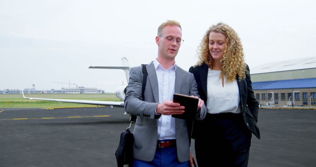 Business Professionals Collaborating on Airport Tarmac Using Tablet Technology