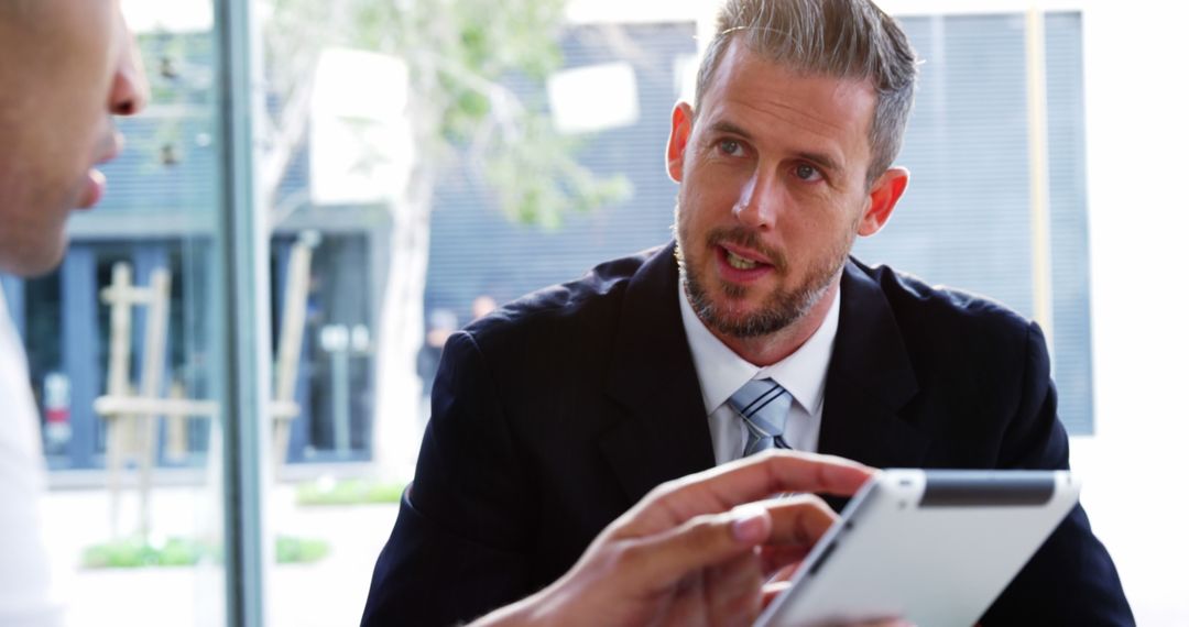 Businessman Discussing Project on Tablet in Modern Office - Free Images, Stock Photos and Pictures on Pikwizard.com