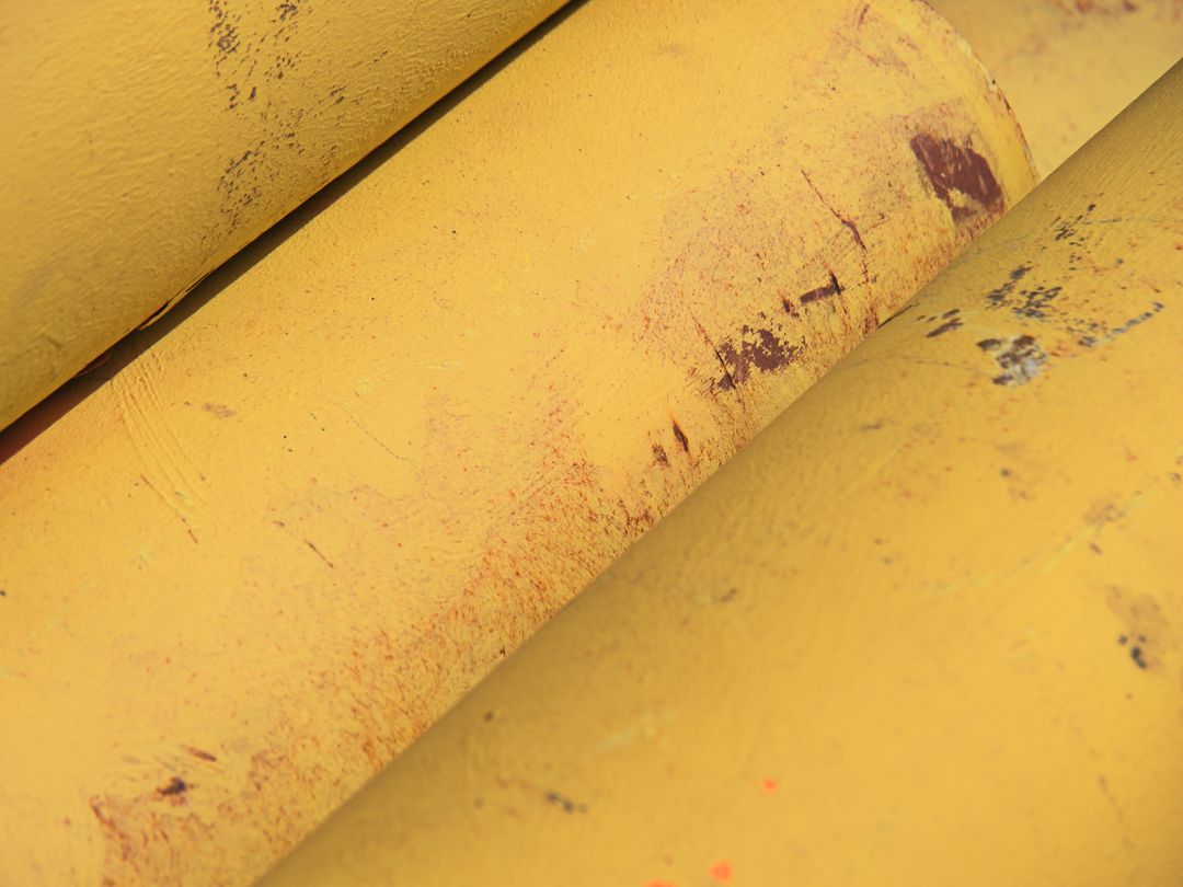 Weathered Yellow Metal Pipe Texture with Rust Marks and Chipped Paint for Industrial Use