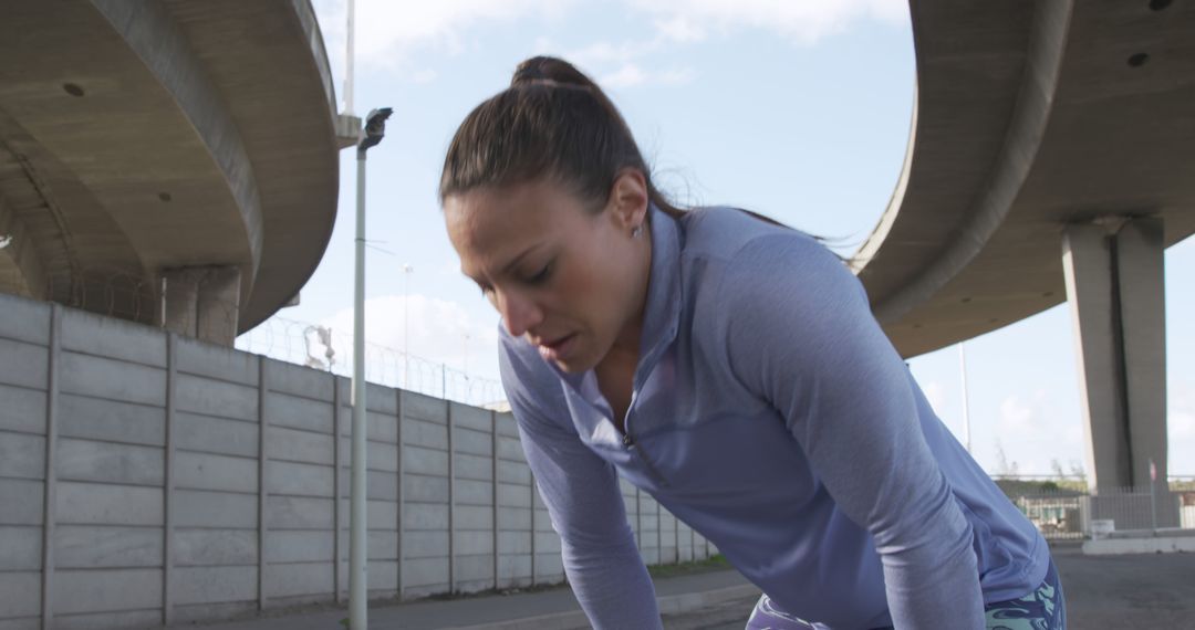 Exhausted Female Athlete Resting Under Highway Overpass - Free Images, Stock Photos and Pictures on Pikwizard.com