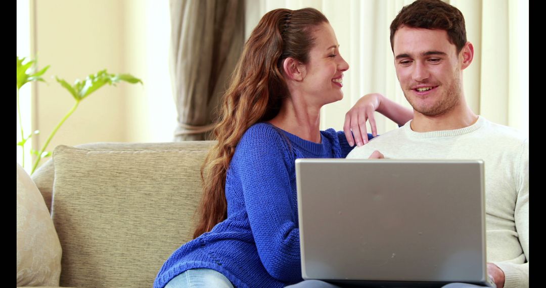 Happy Couple Relaxing on Sofa with Laptop Enjoying Leisure Time