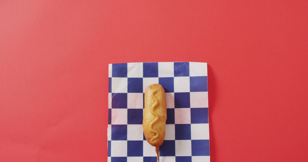 Image of corn dog with mustard on a red surface - Free Images, Stock Photos and Pictures on Pikwizard.com