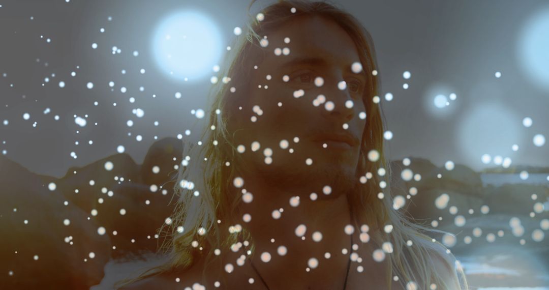 Man on Rocky Seashore with Enchanting Light Particles