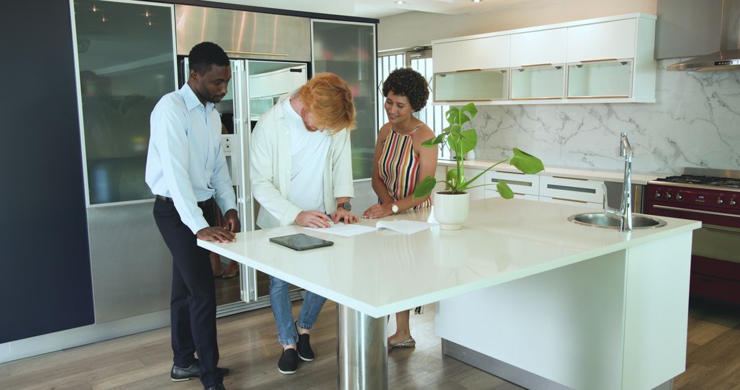 Couple Signs Real Estate Contract With Estate Agent in Modern Kitchen