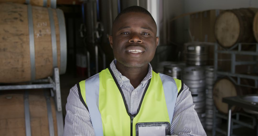 Warehouse Worker Wearing High-Visibility Vest Smiling at Camera - Free Images, Stock Photos and Pictures on Pikwizard.com