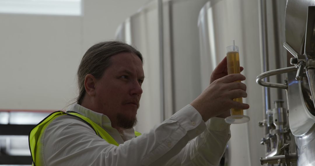 Brewery Worker Inspecting Beer Sample in Fermentation Tank - Free Images, Stock Photos and Pictures on Pikwizard.com