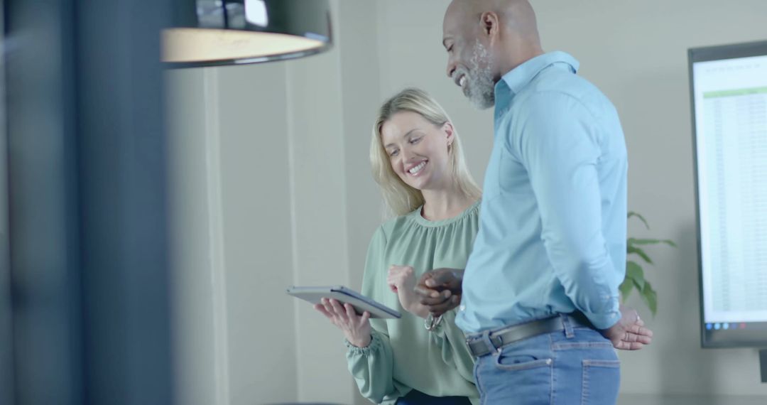 Two Colleagues Analyzing Financial Data on Tablet in Office