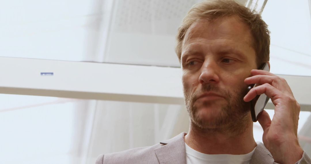 Businessman Discussing on Smartphone in Bright Modern Building