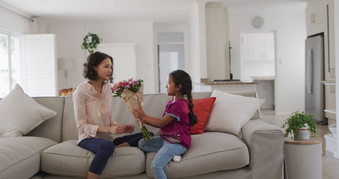 Daughter Giving Flowers to Mother in Modern Living Room - Free Images, Stock Photos and Pictures on Pikwizard.com