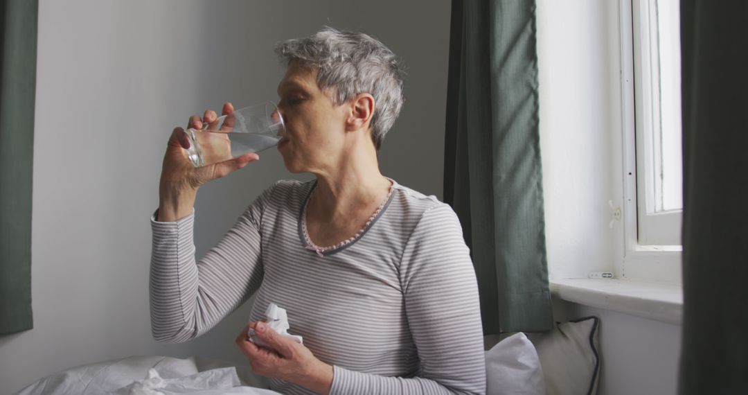 Elderly Woman Drinking Water at Home - Free Images, Stock Photos and Pictures on Pikwizard.com