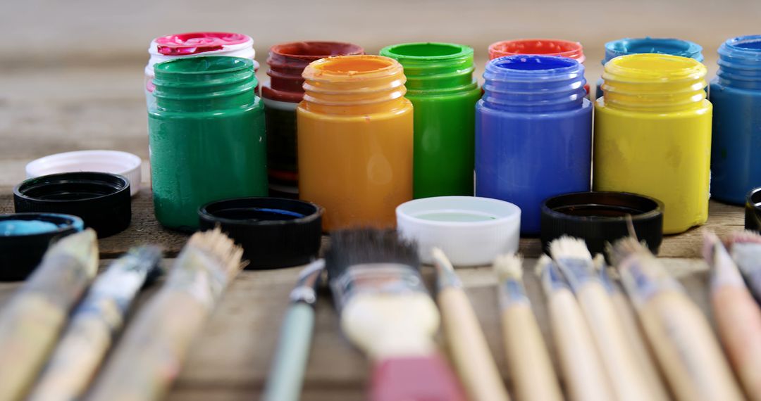 Colorful Acrylic Paint Jars with Brushes on Wooden Table - Free Images, Stock Photos and Pictures on Pikwizard.com