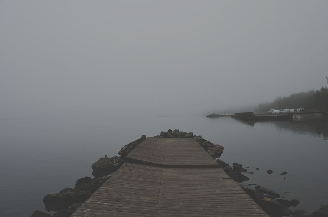 Misty Morning on Calm Lake with Wooden Dock and Rocks - Free Images, Stock Photos and Pictures on Pikwizard.com