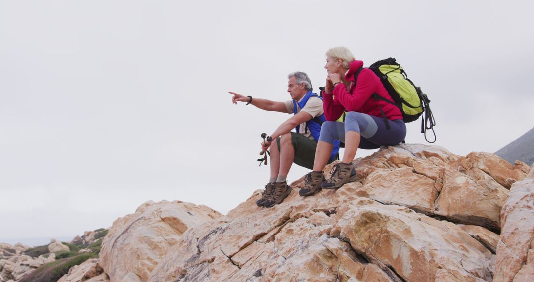 Senior couple hiking on mountain top looking at view - Free Images, Stock Photos and Pictures on Pikwizard.com