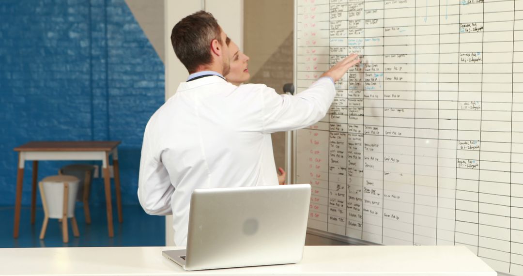 Doctors Reviewing Patient Information on Whiteboard in Medical Office - Free Images, Stock Photos and Pictures on Pikwizard.com