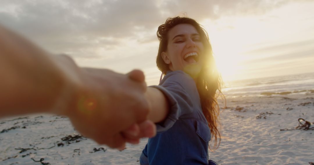 Happy Woman Holding Hand at Beach Sunset - Free Images, Stock Photos and Pictures on Pikwizard.com