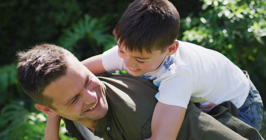 Father Giving Son Piggyback Ride in Lush Garden - Free Images, Stock Photos and Pictures on Pikwizard.com