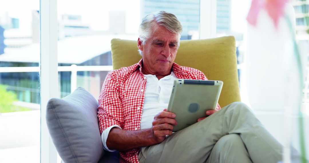 Senior Man Using Tablet Technology Indoors Comfortable Modern Living - Free Images, Stock Photos and Pictures on Pikwizard.com