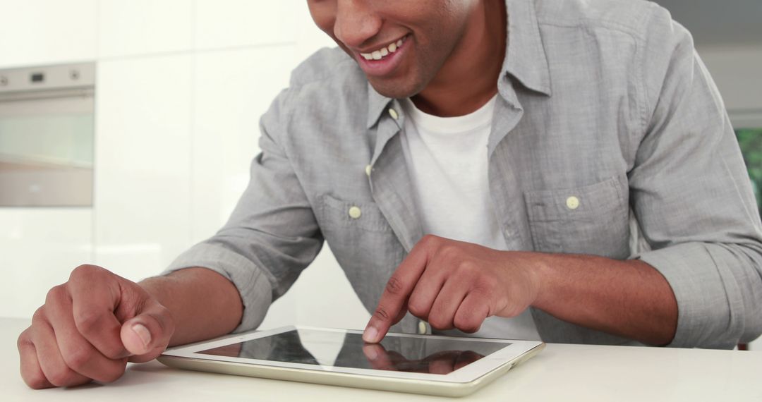 Smiling Man Using Tablet in Modern Kitchen - Free Images, Stock Photos and Pictures on Pikwizard.com