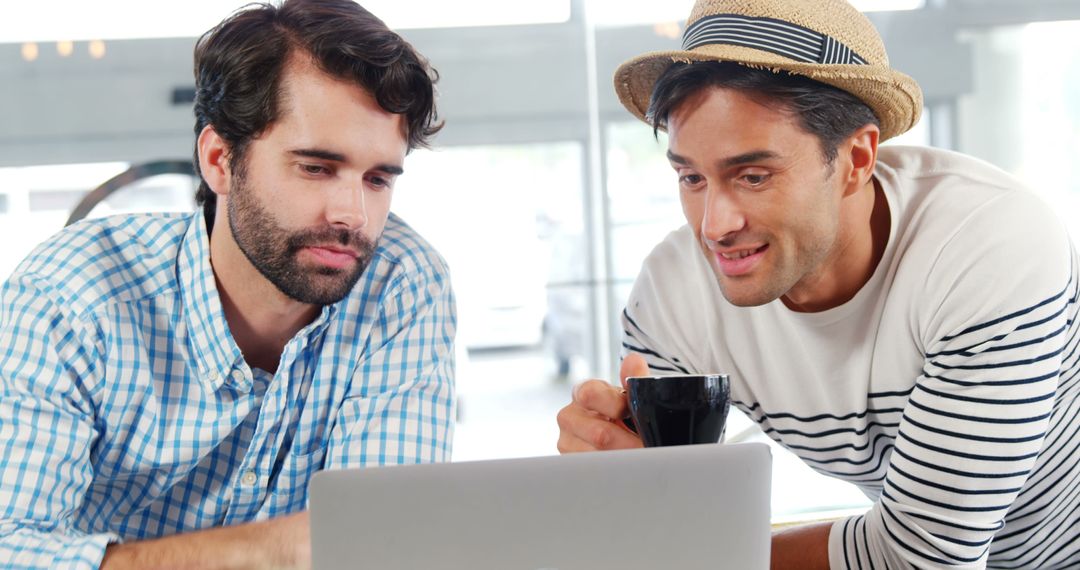 Two Men Collaborating on Laptop in Modern Office - Free Images, Stock Photos and Pictures on Pikwizard.com