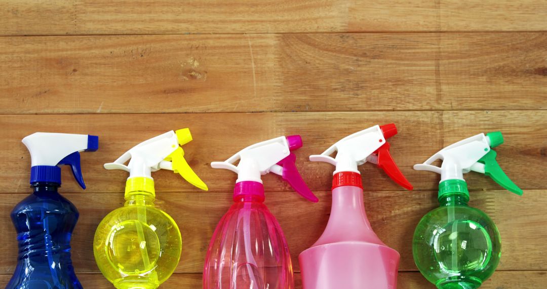 Colorful Cleaning Spray Bottles Arranged on Wooden Surface - Free Images, Stock Photos and Pictures on Pikwizard.com