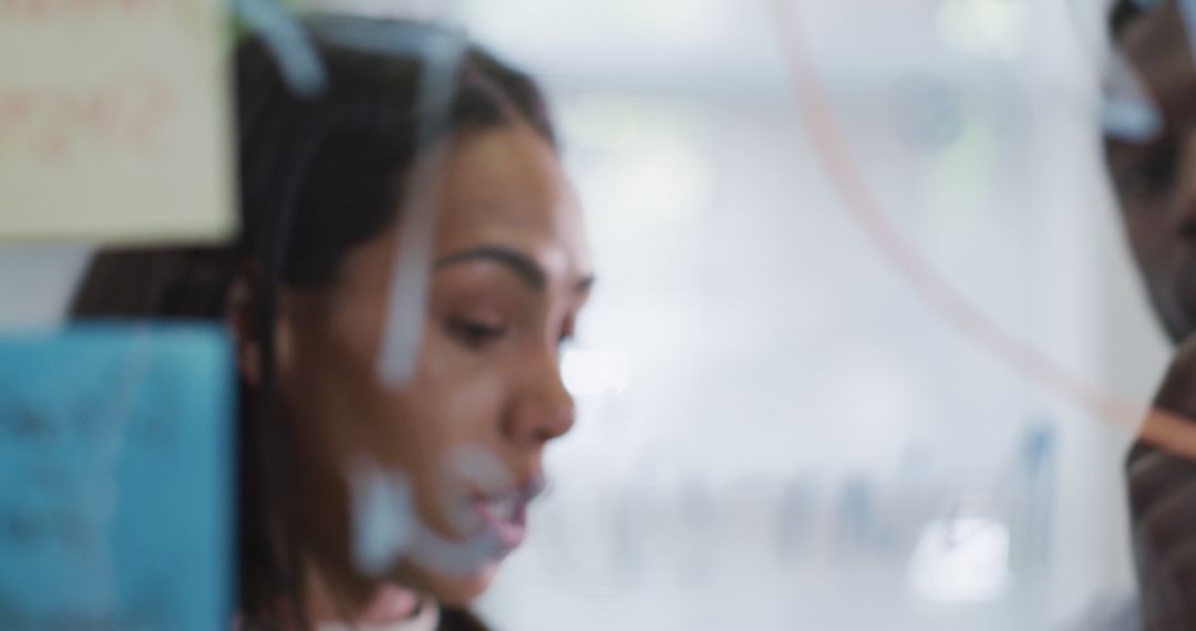 Collaborative Team Meeting Behind Glass Panel
